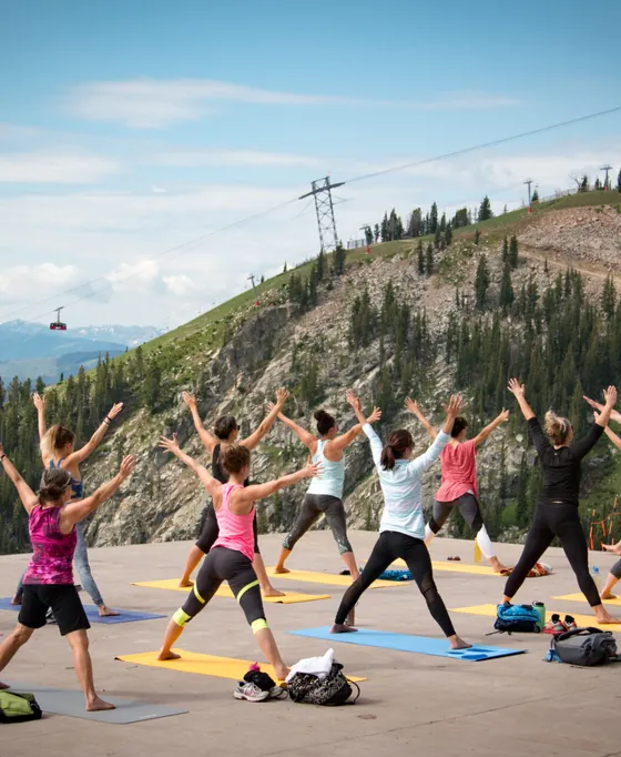 A yoga class on a mountaintop deck above the valley