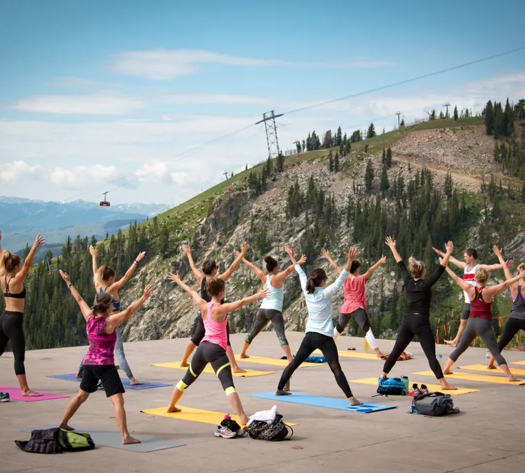 A yoga class on a mountaintop deck